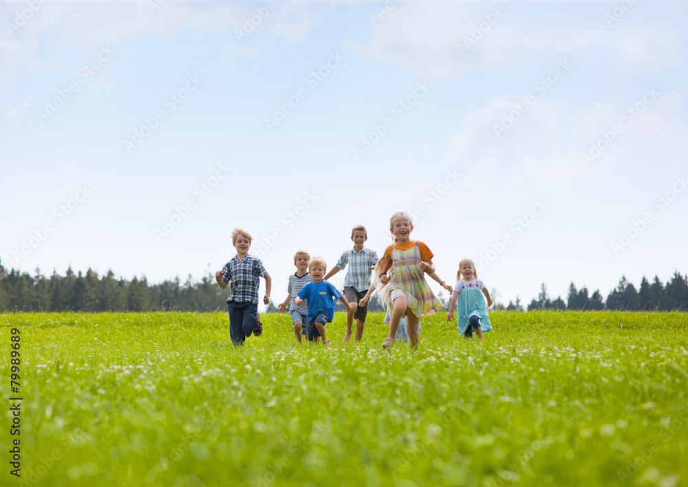 Germany, Bavaria, Group of children running through meadow Germany, Bavaria, Group of children running through meadow