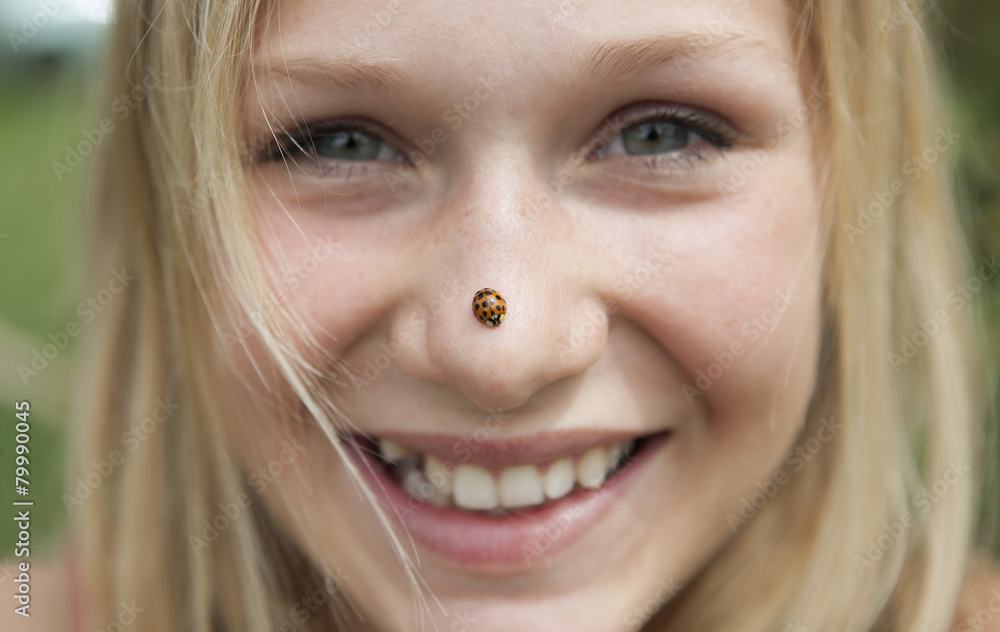 Austria, Teenage girl with ladybird on her nose, smiling, portrait Austria, Teenage girl with ladybird on her nose, smiling, portrait