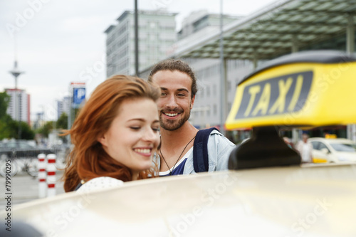 Germany, Berlin, Young couple taking taxi photo