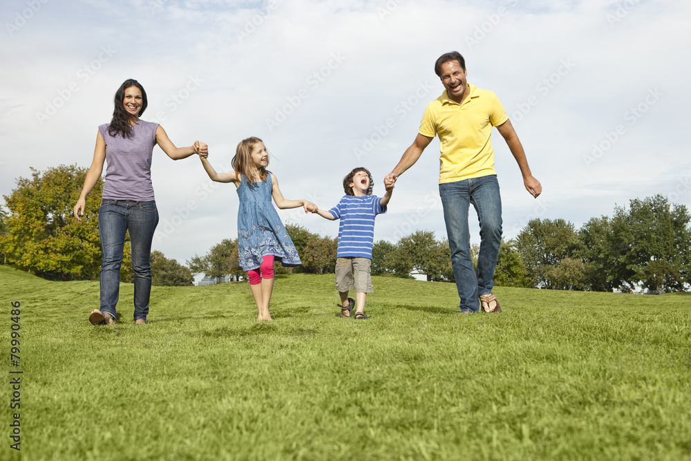 Germany, Bavaria, Family walking in grass at park Germany, Bavaria, Family walking in grass at park