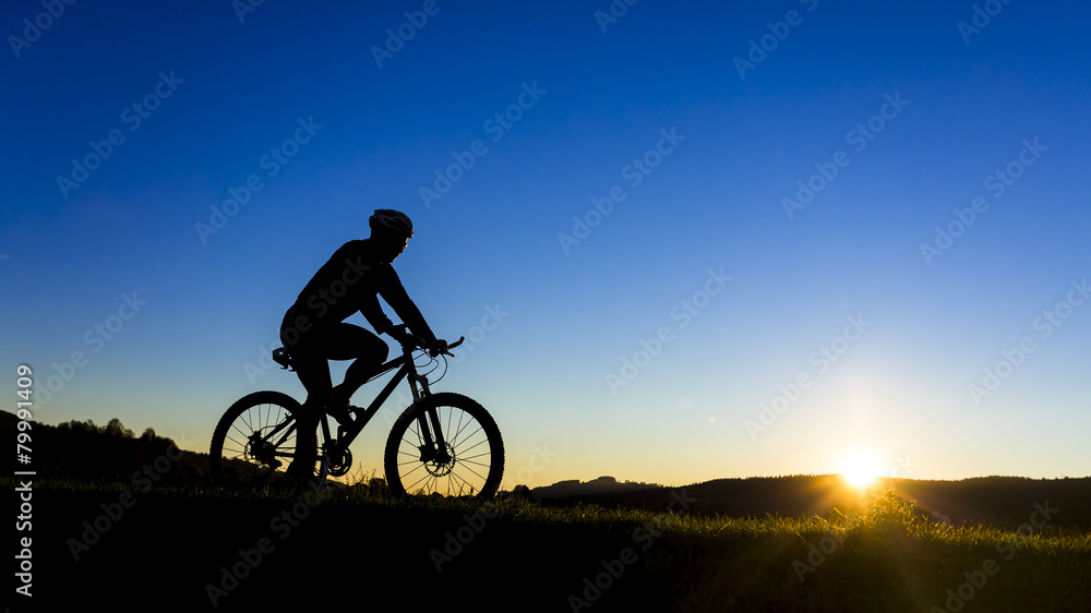 Germany, Winterbach, cyclist on a mountain bike at sunset Germany, Winterbach, cyclist on a mountain bike at sunset