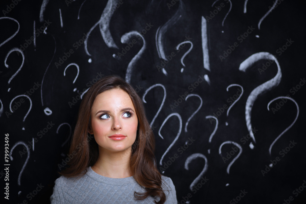 Young girl with question mark on a gray background Young girl with question mark on a gray background