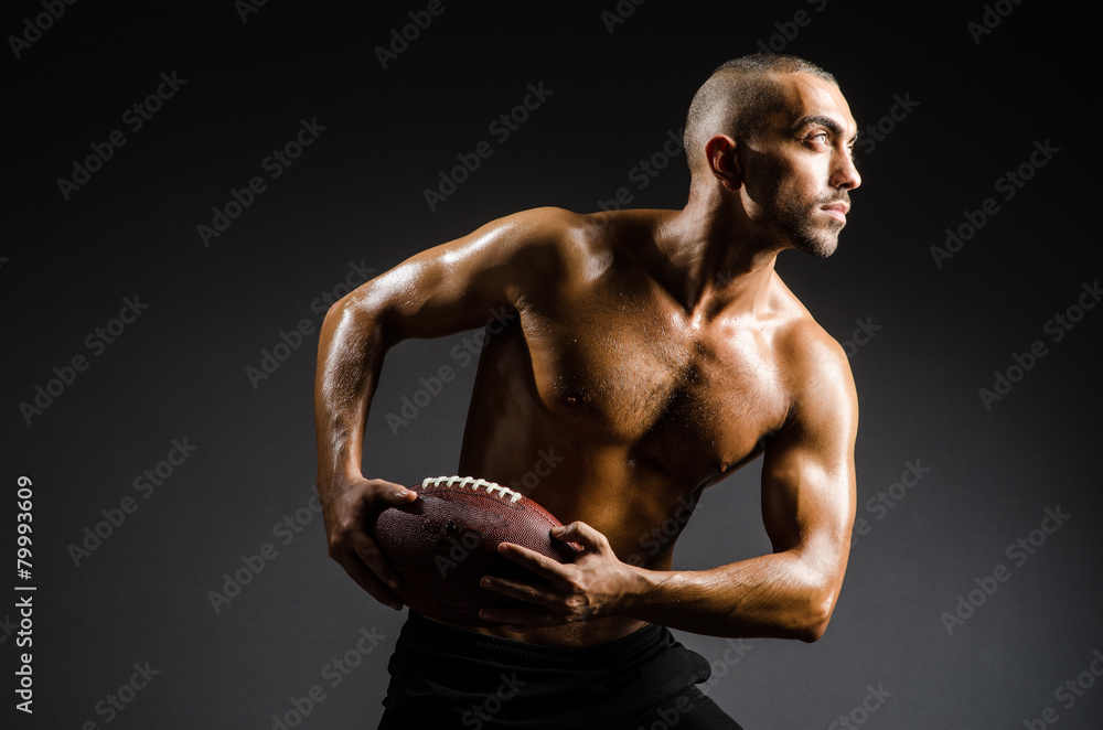 Muscular football player with ball