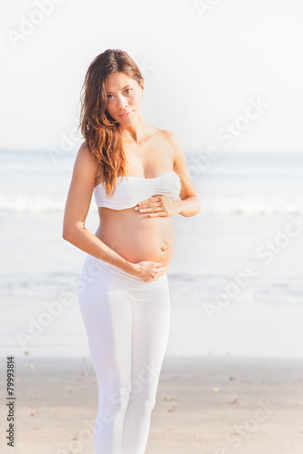 Schwangeres Model steht am Strand