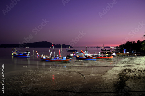 boats on the beach at night in phuket.