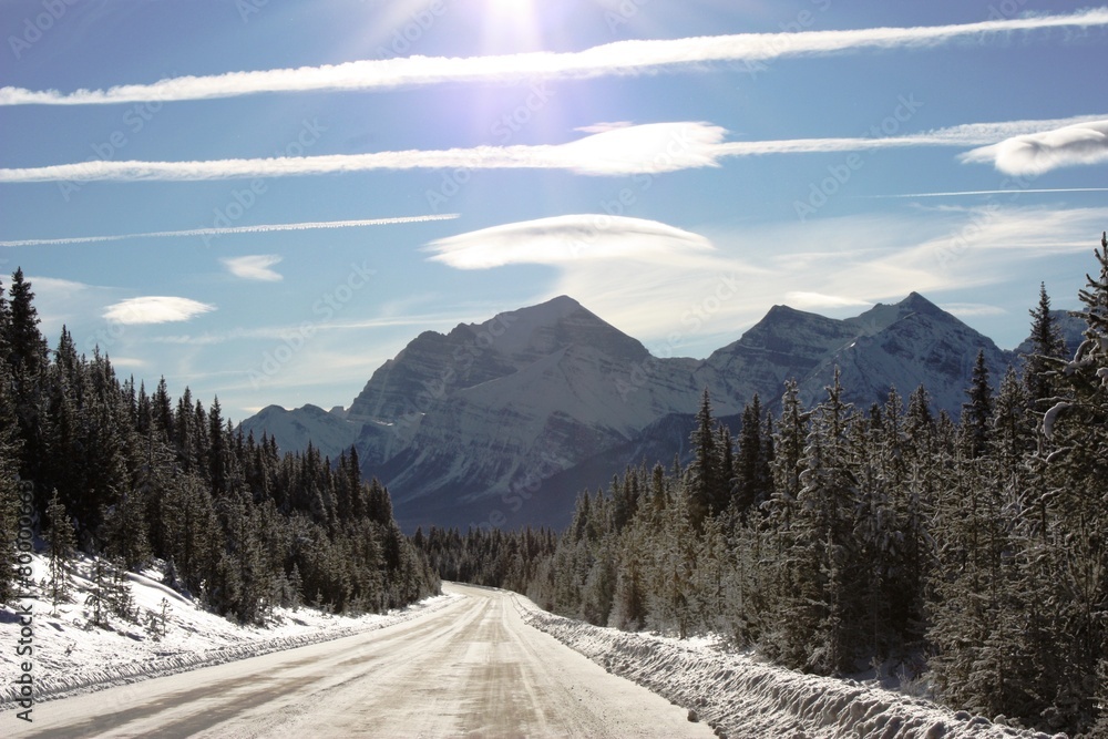 Frozen road in front of a mountain under blue sky