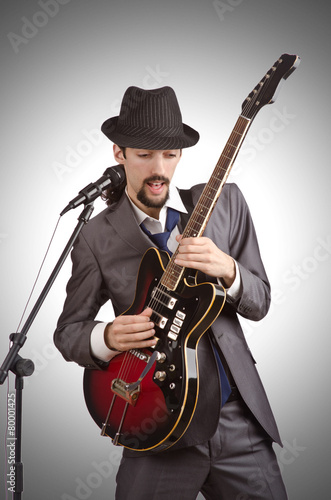 Businessman playing the guitar on white