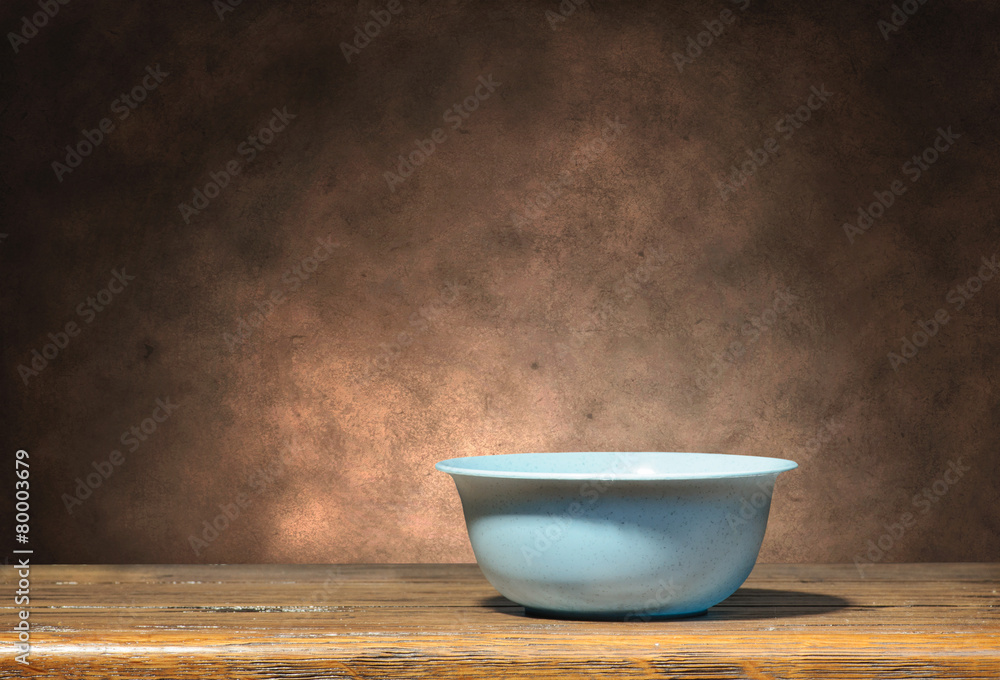 Blue bowl on brown grunge background Blue bowl on brown grunge background