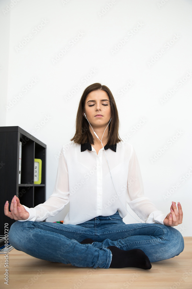Young woman meditating at the table in office Young woman meditating at the table in office