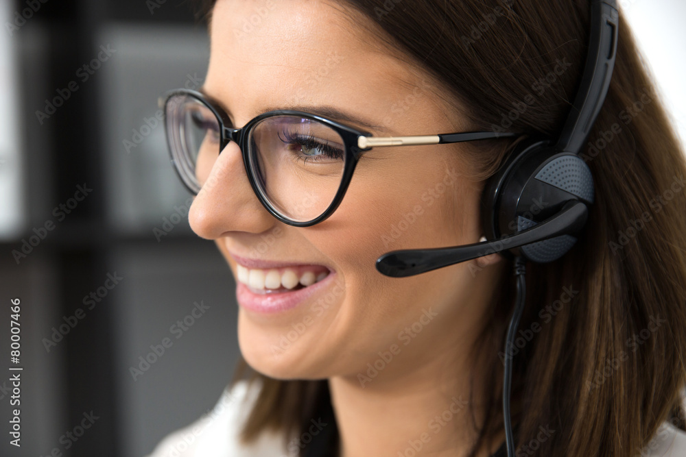 Closeup portrait of a smiling female support operator in headset Closeup portrait of a smiling female support operator in headset