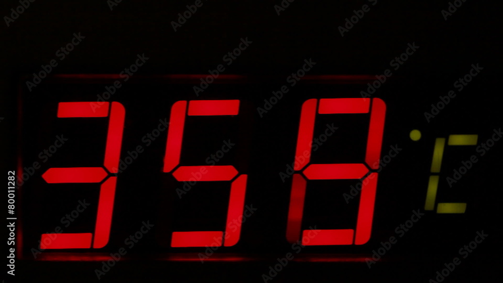 Thermometer with red digits shows the temperature rise