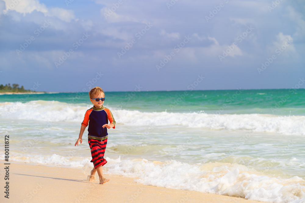 little boy running on sand tropical beach