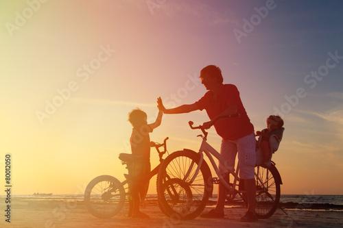Biker family silhouette, father with two kids on bikes © nadezhda1906