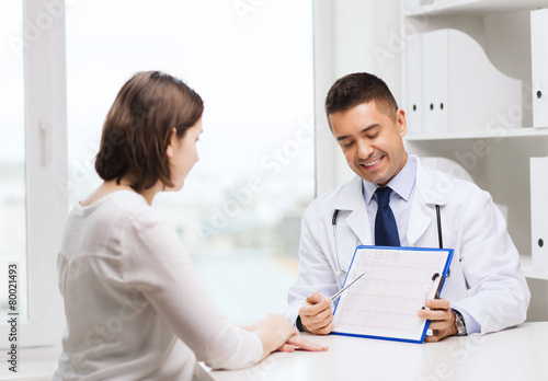 smiling doctor and young woman meeting at hospital