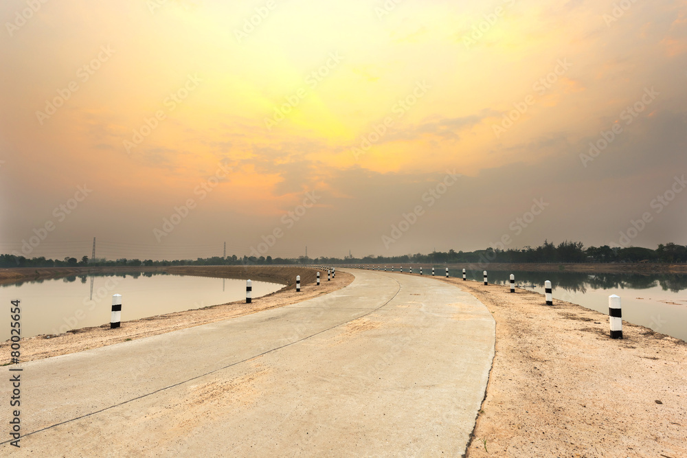 Concrete road and lake landscape in the morning