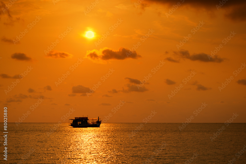 Beautiful sunset over the island beach with boat silhouette