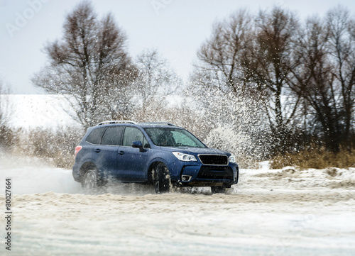 Powerful offroader car sliding by lake ice