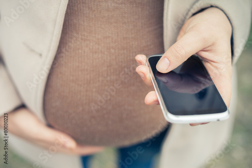 pregnant woman calling by mobile phone photo