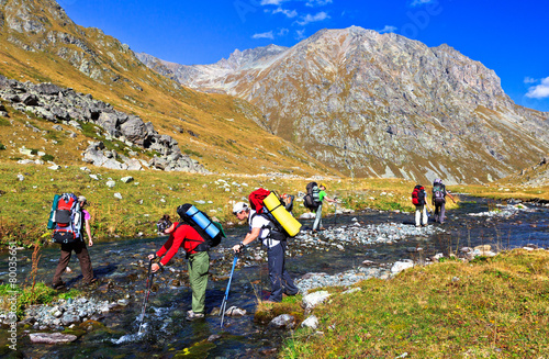 tourists overcome a mountain river