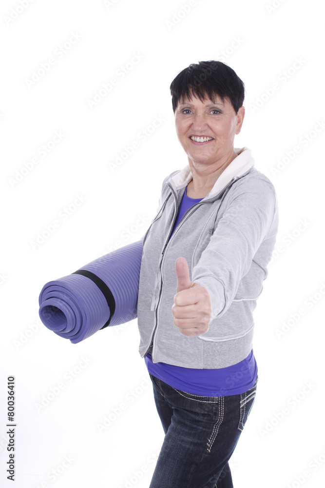 Ältere Frau mit Gymnastikmatte und Daumen hoch isoliert Ältere Frau mit Gymnastikmatte und Daumen hoch isoliert