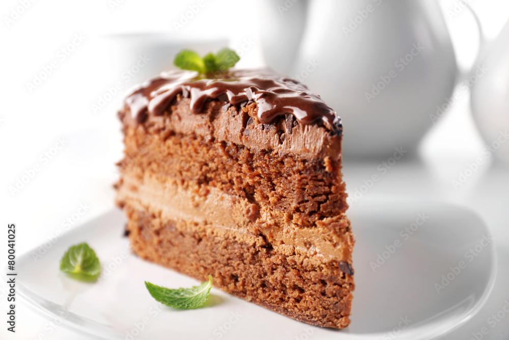 Delicious chocolate cake on plate on table on light background Delicious chocolate cake on plate on table on light background