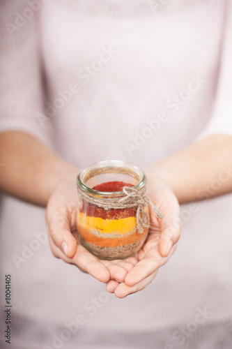 Close up photo of colored salt in female hands