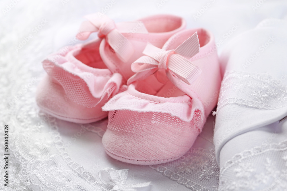 Pink baby boots on cloth close-up Pink baby boots on cloth close-up