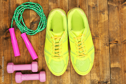 Shoes and sports equipment on wooden floor, top view