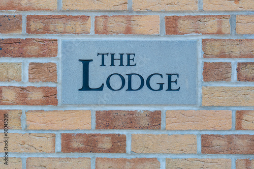 Картината върху платно Sign 'The Lodge' on a brick wall
