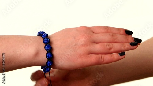 Woman shows popular bracelet shamballa on hand, white background photo