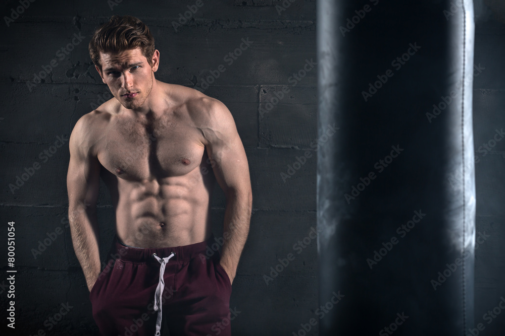 Athletic man with naked torso near concrete wall