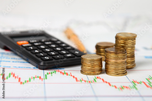 Calculator and stacks of coins