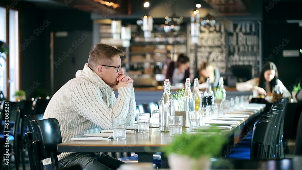 Sad man sitting in the restaurant and looking around Sad man sitting in the restaurant and looking around