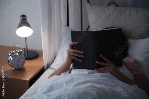 Junge Frau im Bett am lesen photo