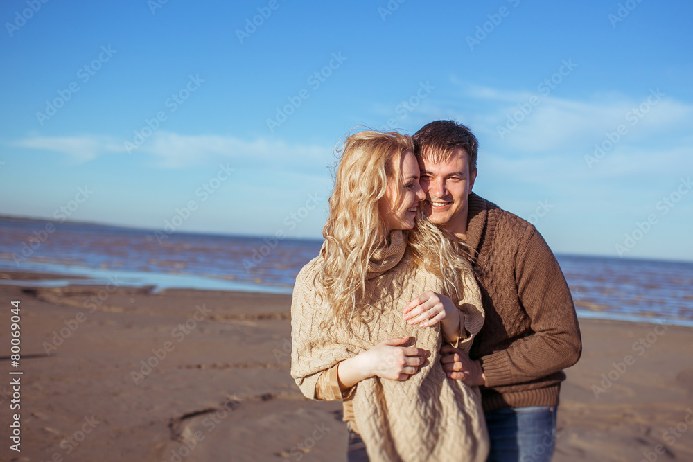 A young couple are standing close to each other and smiling
