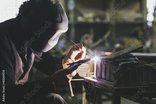 Welder working in iron casting foundry