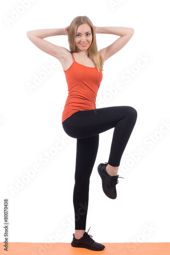 Beautiful woman in sportswear training legs and back on a mat.