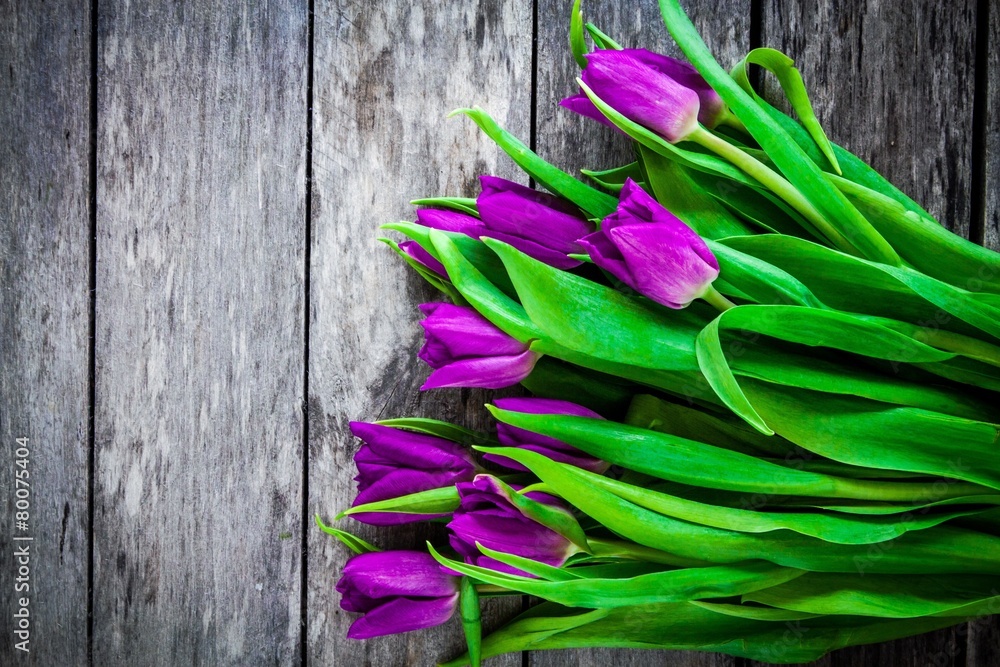 Fototapeta premium bouquet of purple tulips on a rustic background