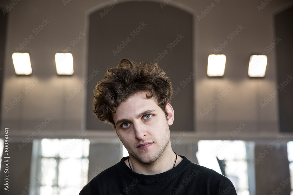 Portrait of a young serious man with curly hair Portrait of a young serious man with curly hair