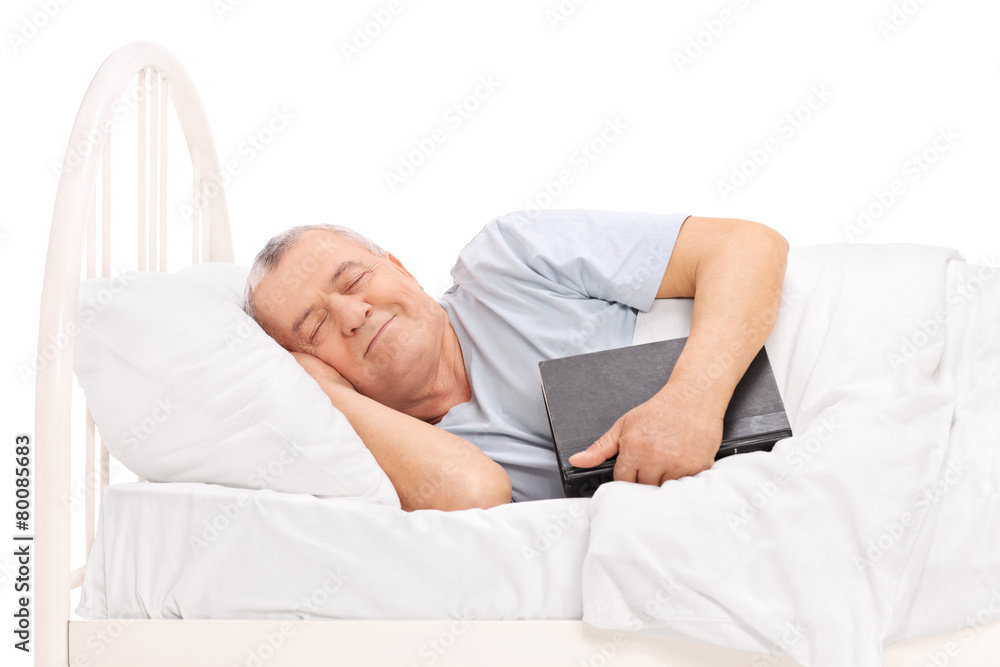 Senior sleeping in a bed and holding a book Senior sleeping in a bed and holding a book