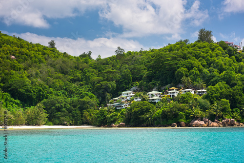 View of Seychelles coastline with houses in the forest. © dvoevnore