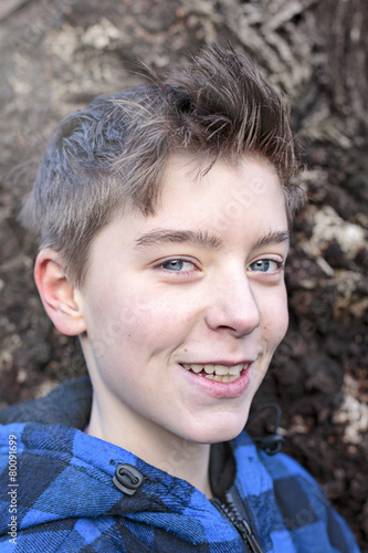 portrait of a smiling teenage boy with blue plaid lumberjack jac