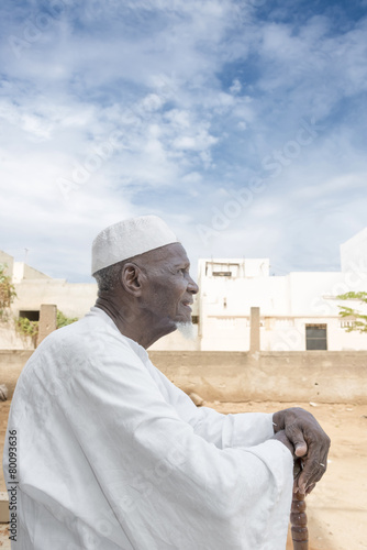 African man sitting in front of his house, eighty years old © Diversity Studio
