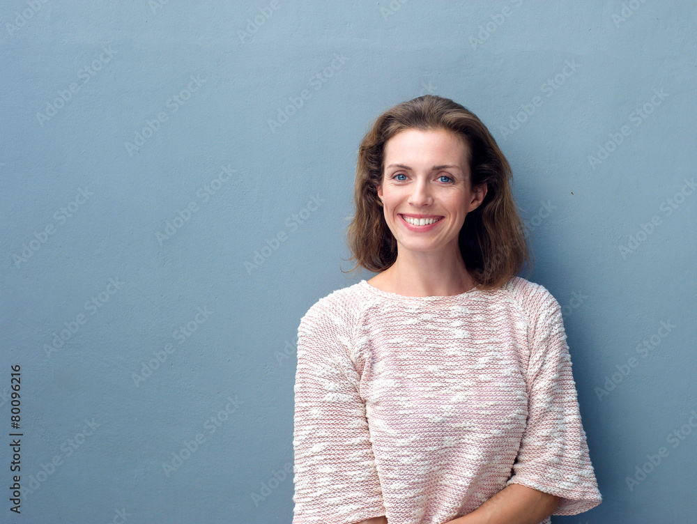 Beautiful mid adult woman smiling on gray background Beautiful mid adult woman smiling on gray background