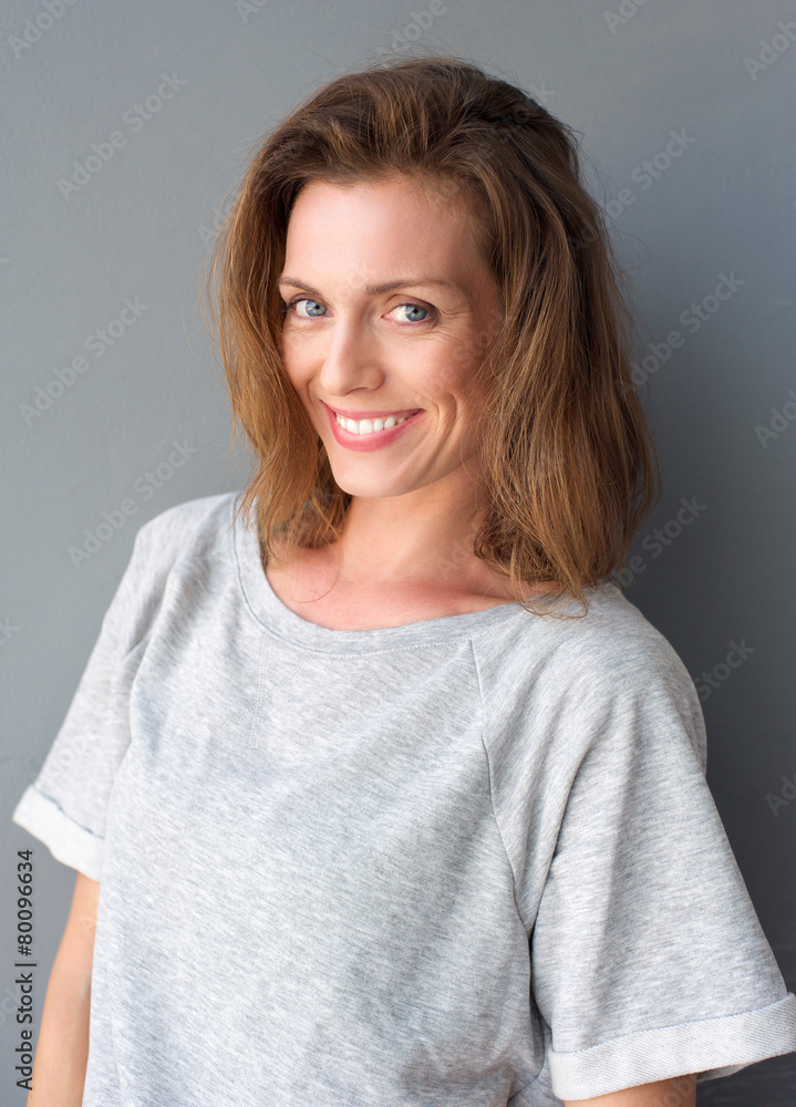 Beautiful mid adult woman smiling on gray background Beautiful mid adult woman smiling on gray background