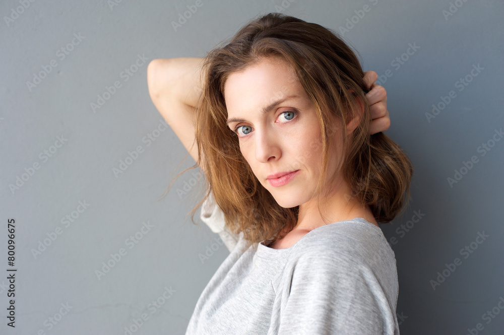 Elegant mid adult woman posing with hand in hair Elegant mid adult woman posing with hand in hair