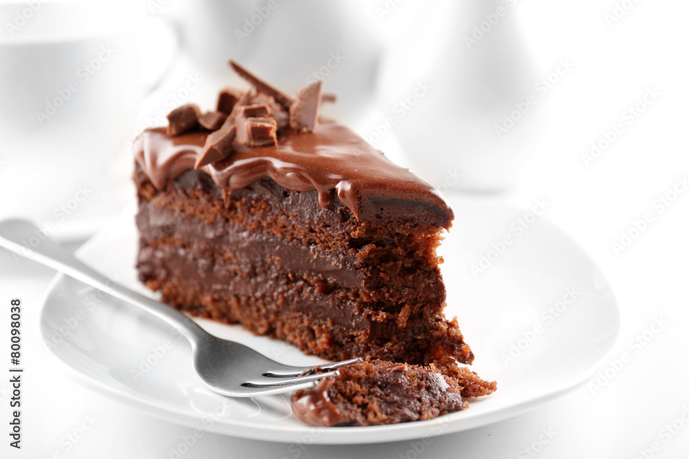 Delicious chocolate cake on plate on table on light background Delicious chocolate cake on plate on table on light background