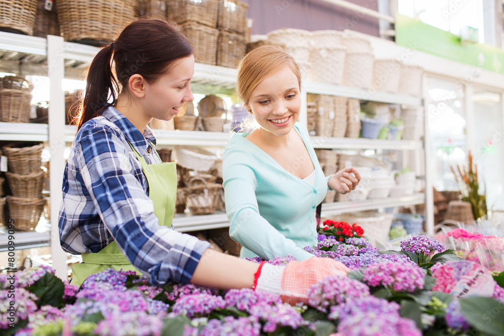 happy women choosing flowers in greenhouse