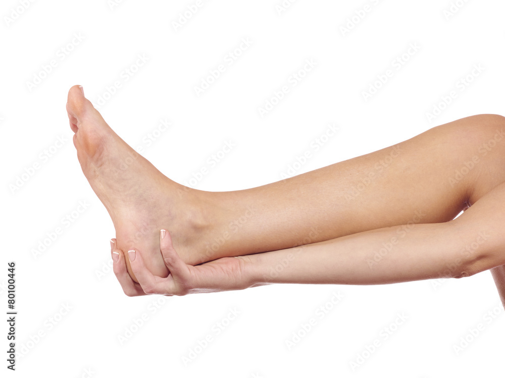 A young woman massaging her painful ankle A young woman massaging her painful ankle