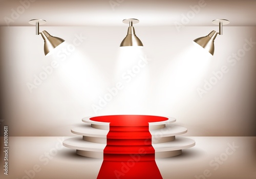 Showroom with red carpet leading to a podium and three lights. V